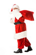© LIGHTFIELD STUDIOS - side view of santa claus walking with sack and looking at camera isolated on white