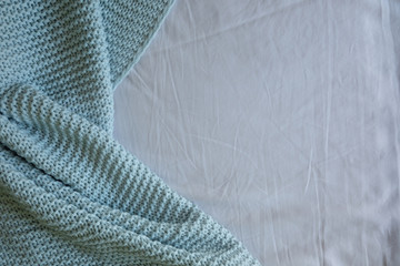 Handmade blue knitted wool blanket on bed, knitting wool texture background