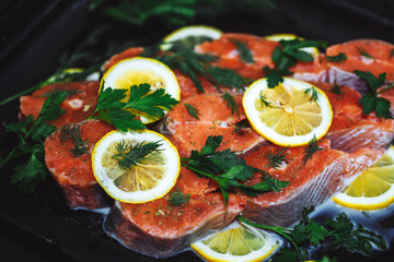 Close up of red fish sliced with slices of lemon and dill. A delicious dish