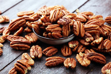 Pecan Nuts On A Rustic Wooden Table And Pecan Nuts In Bowl