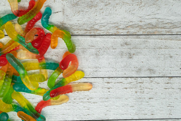 Wall Mural - Pile of colorful gummy worms on a wooden background