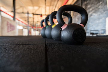 Wall Mural - Row of kettlebell or girya weights in a gym weight in a fitness and active healthy lifestyle concept