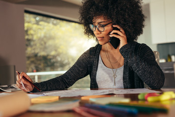 Businesswoman talking on smartphone and working in office