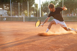 Fototapeta Młodzieżowe - Professional tennis player man playing on court in afternoon.