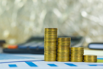 Coin stack and financial graph paper sheet with calculator on working table, business planning vision and finance analysis concept.