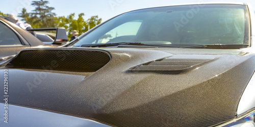 Fényképezés Carbon fiber hood of a silver car on a sunny day
