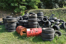 Old Tires And Rusty Metal Barrels At The Landfill