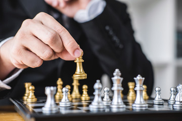Wall Mural - Hands of confident businessman playing chess game to development analysis new strategy plan, leader and teamwork concept for win and success