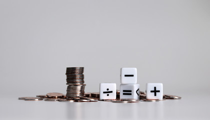 White cubes with arithmetic symbols and pile of coins.