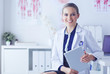© lenets_tan - Portrait of woman doctor at hospital corridor, holding tablet computer, looking at camera, smiling