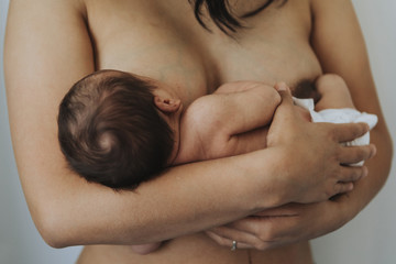Wall Mural - naked mother holding her infant baby