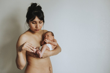 Wall Mural - naked mother holding her infant baby