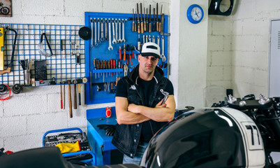 Wall Mural - Mechanic posing with a customized motorcycle in his workshop