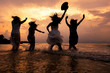 © Nattanon - Summer silhouette of Asian girls gang are jumping in sea on the beach. Vacation on weekend concept. Cinema film tone with grain.