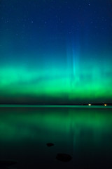 Wall Mural - Beautiful northern lights aurora borealis over lake in finland