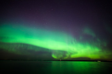 Wall Mural - beautiful northern lights aurora borealis over lake in finland