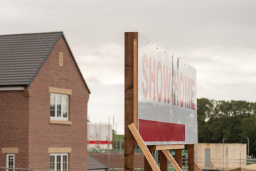 Wall Mural - Showhome marketing sign post over new residential homes development estate in England