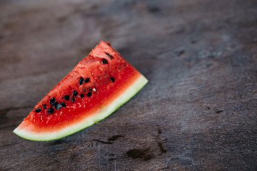 fresh ripe slices of watermelon on a darl wooden background with copy space