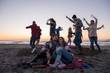 © .shock - Couple enjoying with friends at sunset on the beach