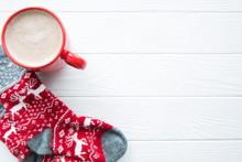 Christmas Red Cup With Hot Chocolate. Red Socks With Christmas Ormanent And Deer. Hot Cocoa With Milk On White Wooden Background, Top View, Copy Space.