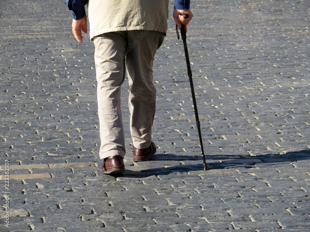 Man walking with a cane down the street. Concept for old age, diseases ...