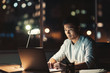 © mavoimages - Asian businessman using a laptop at his desk at night