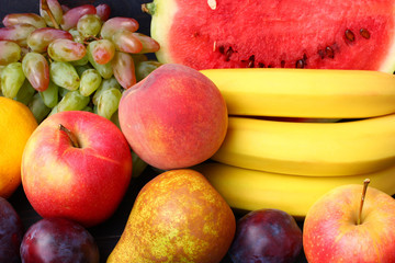 Wall Mural - Tasty fruits on a dark background close-up