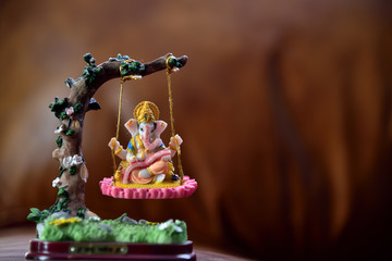 Hindu God-Ganesha in art form sitting on a swing. Hindu Lord Ganesha provide success, prosperity and remover trouble.