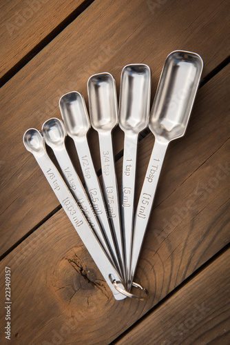 Fotografie, Obraz Measuring Spoons Isolated on Wooden Table