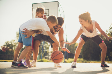 Wall Mural - Family playing basketball together.