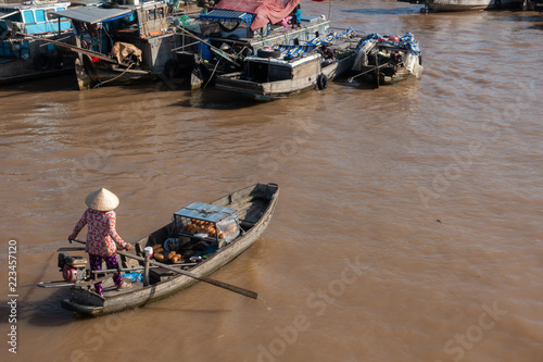 Foto Tourists, people buy and sell food, vegetable, fruits on vessel, boat, ship in Cai Rang floating market, Mekong River