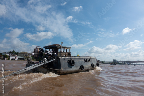Fotografia Tourists, people buy and sell food, vegetable, fruits on vessel, boat, ship in Cai Rang floating market, Mekong River