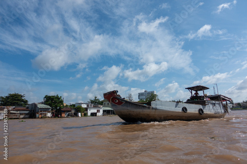 Foto Tourists, people buy and sell food, vegetable, fruits on vessel, boat, ship in Cai Rang floating market, Mekong River