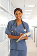 © Mark Adams - Young professional doctor wearing scrubs and using clipboard to write notes