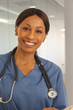 © Mark Adams - Close up of smiling black doctor wearing scrubs indoors health office