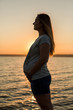 © Mountains Hunter - Young girl pregnant on the beach silhouette