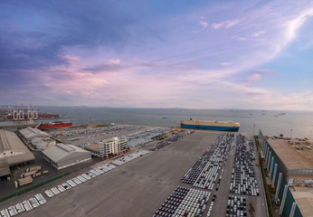 Poster - Aerial view of logistics concept commercial vehicles, cars and pickup trucks waiting to be load on to a roll-on/roll-off car carrier ship at Laem Chabang dockyard in Chonburi Province, Thailand