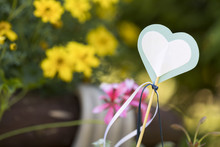 A Heart Cut Out From Paper Amongst Yellow Flowers