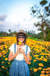 © belart84 - Close up portrait of happy and beautiful young woman relaxing enjoying the fresh beauty of gorgeous orange marigold flowers field in travel and holidays. Bali island.