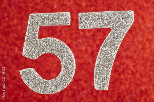 Fotografie, Obraz Number fifty-seven silver color over a red background