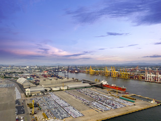 Poster - Aerial view of logistics concept commercial vehicles, cars and pickup trucks waiting to be load on to a roll-on/roll-off car carrier ship at Laem Chabang dockyard in Chonburi Province, Thailand
