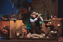 Boy In Pirate Costume Looking Through Telescope On Halloween Nigh