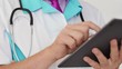 Medical doctor working with digital tablet computer and writting rx prescription for patient