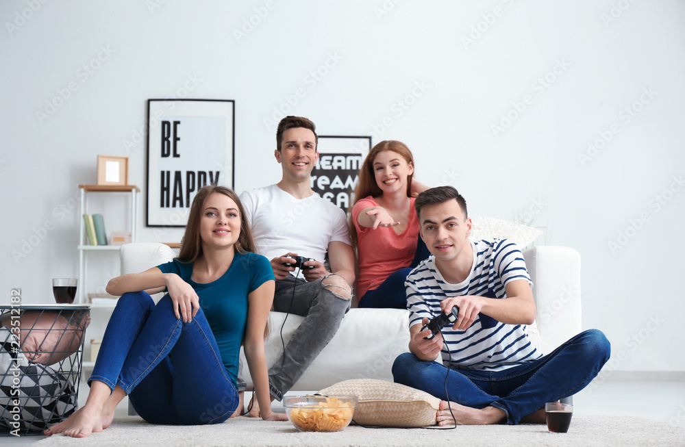 Young people playing video games at home