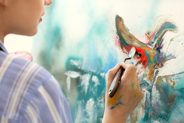 Female artist painting picture in workshop