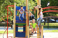 Cute Little Children Having Fun On Playground Outdoors