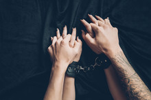 Cropped Shot Of Couple Holding Hands In Foreplay, Woman Wearing Leather Handcuffs