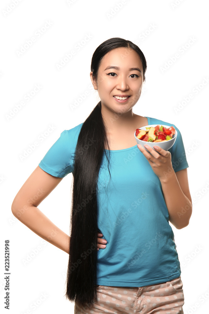 Asian woman with healthy fruit salad on white background