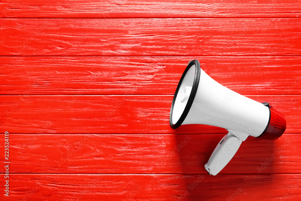 Megaphone on color wooden background