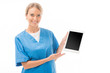 © LIGHTFIELD STUDIOS - smiling young nurse pointing at tablet with blank screen isolated on white